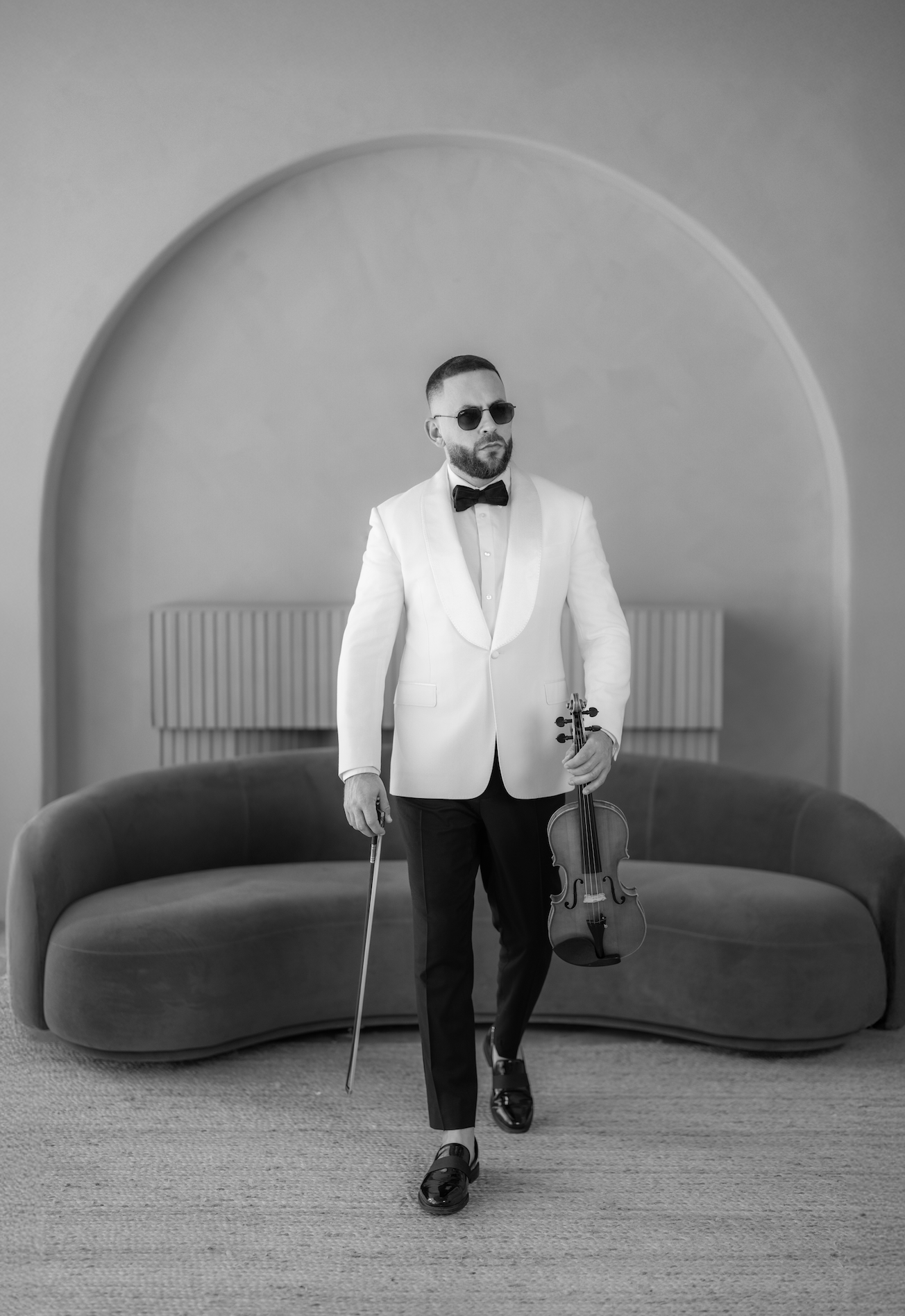 Ronny Moreno professional wedding violinist posing in elegant suit holding violin