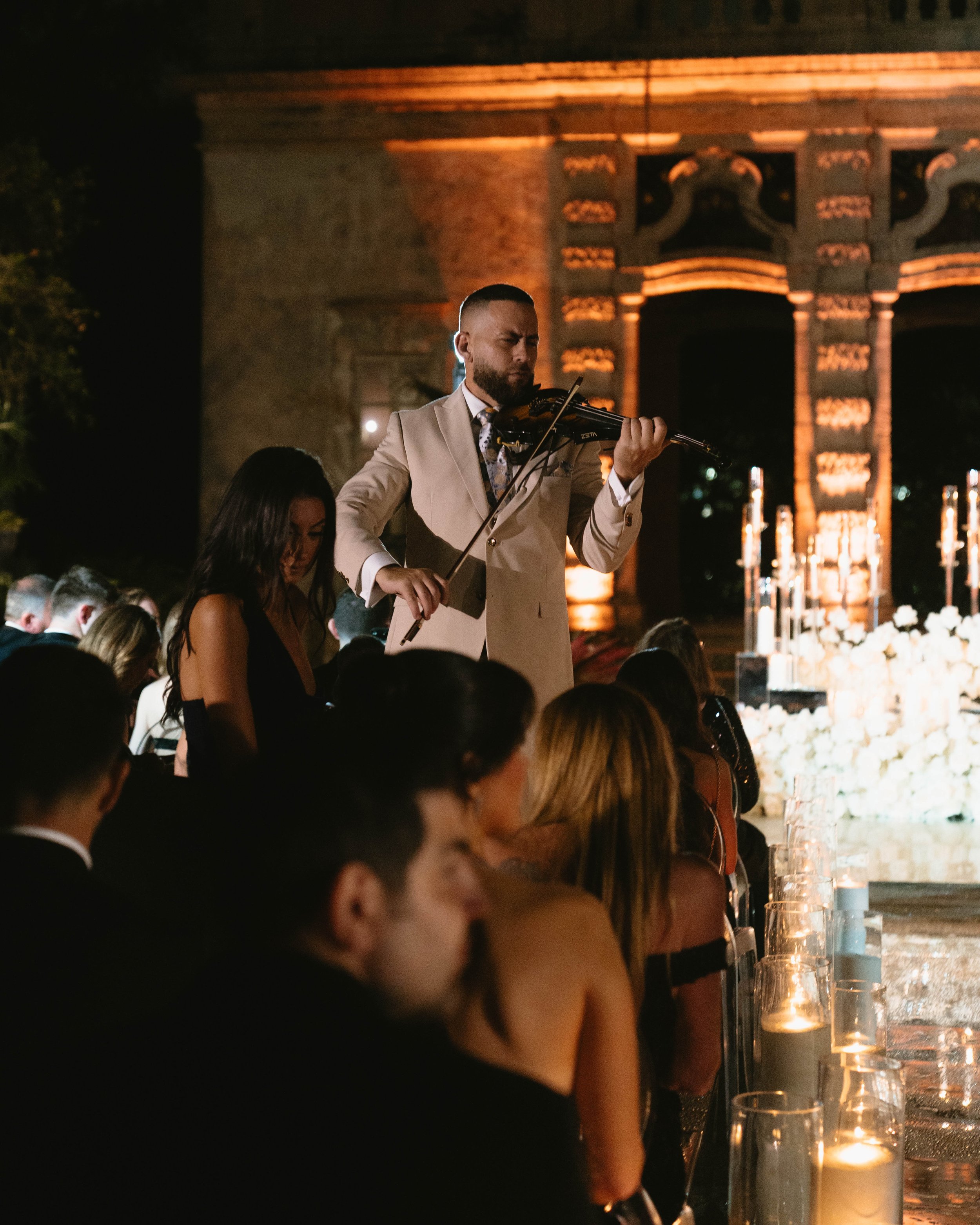 Wedding violinist performing live among guests at Vizcaya Museum & Gardens in Miami