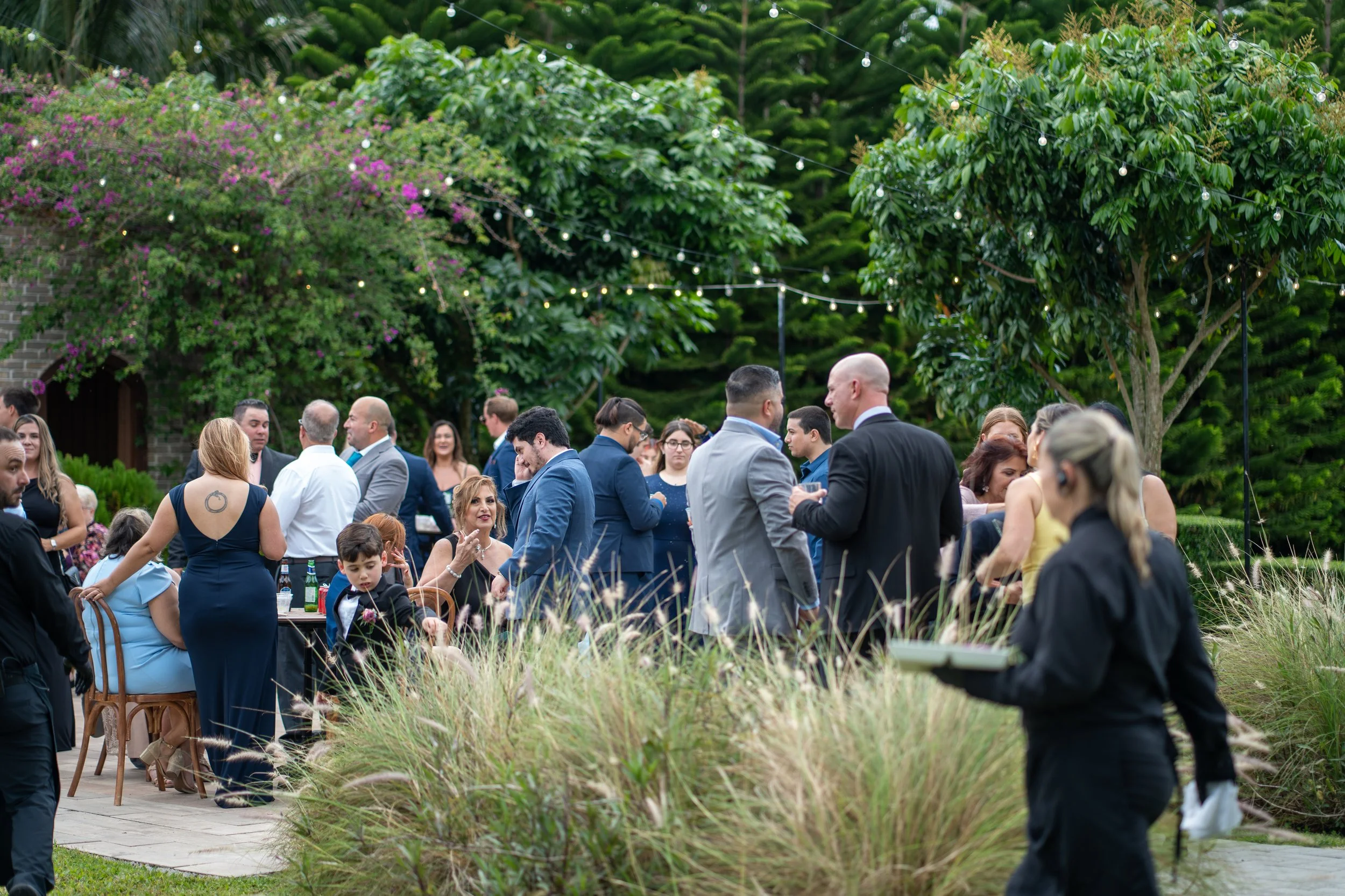 Guests enjoying cocktail hour with live violin at Cinco Farm Gardens