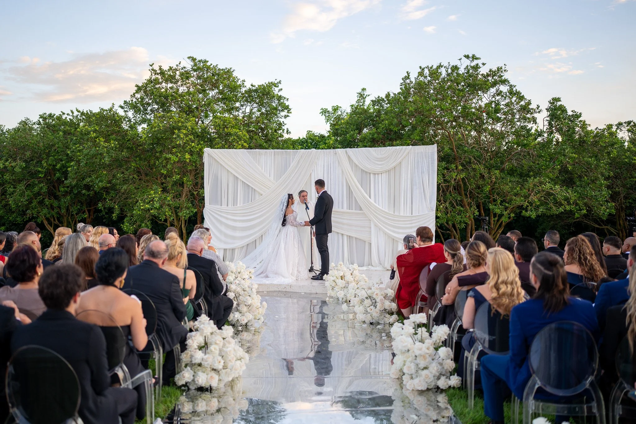Bride and groom during their outdoor wedding ceremony at The White Orchid in Miami