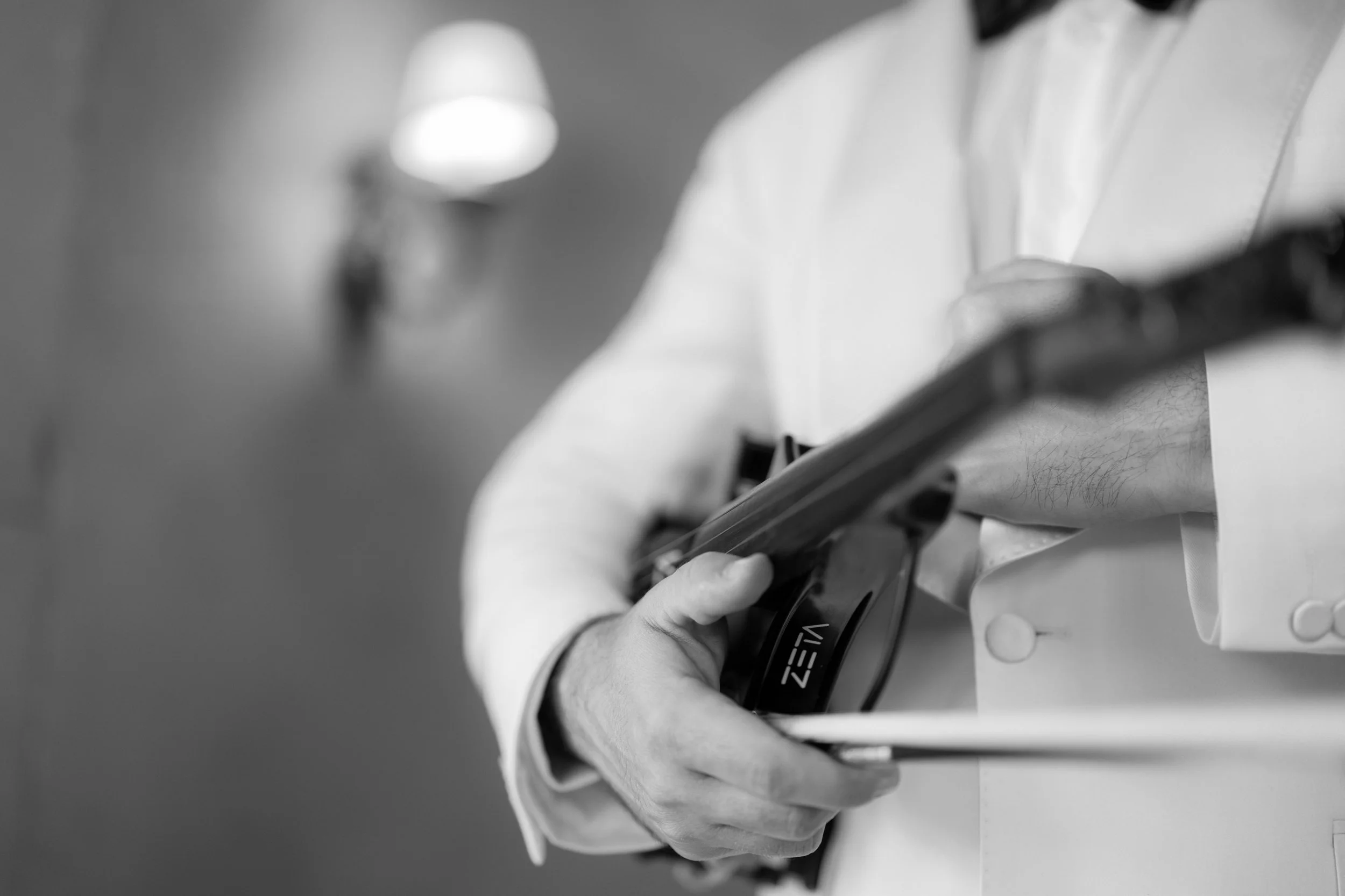 Close-up of a person in a white suit holding a tablet device.