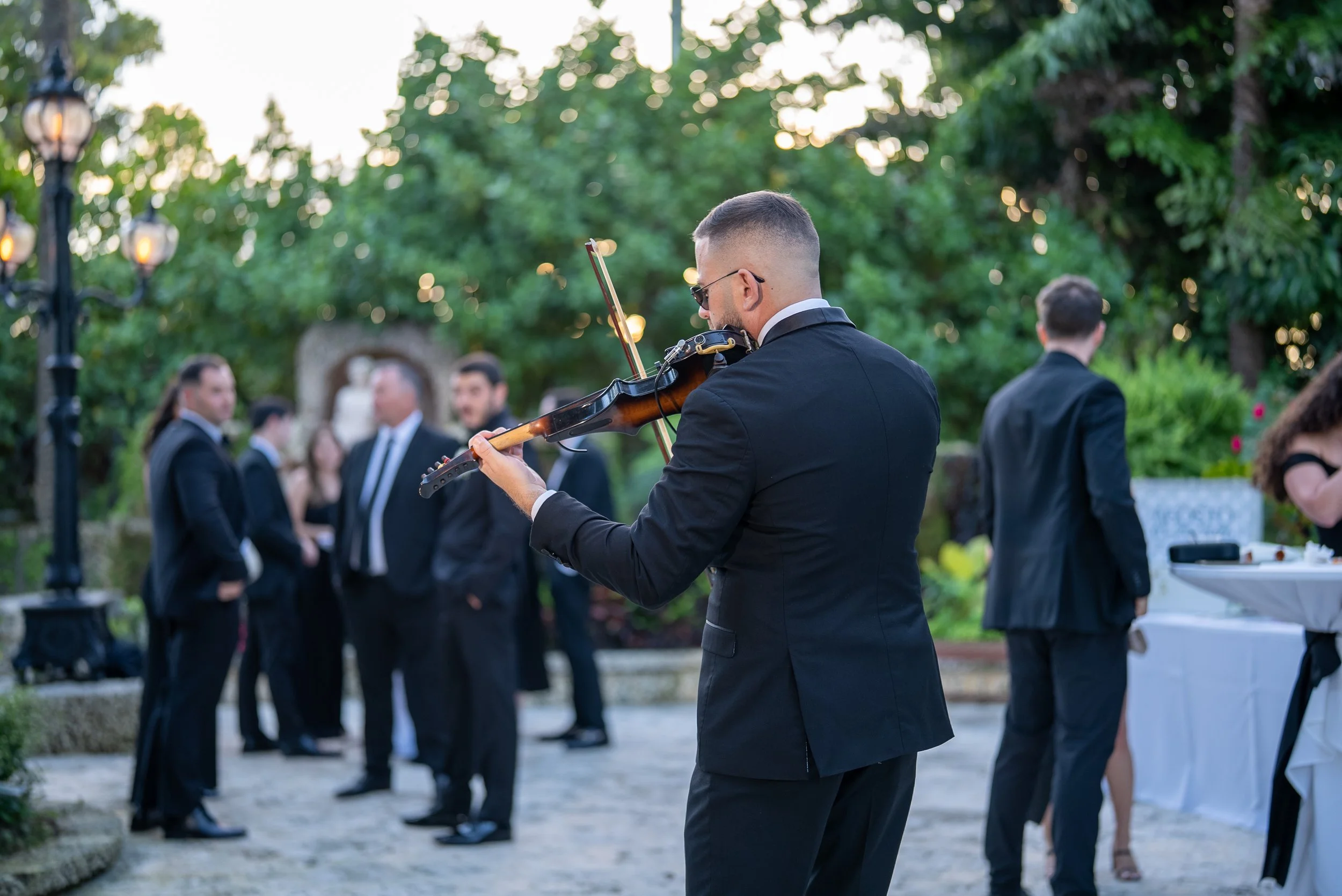 Guests enjoying cocktail hour with live violin at Villa Toscana Miami