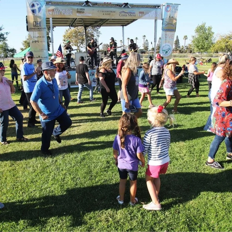 People dancing and enjoying live music at Costa Mesa Foundations Concerts in the park summer series.