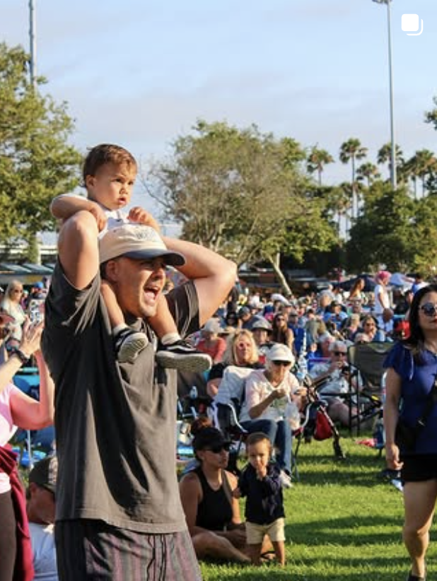 Father enjoying a summer evening with his child at concert in the park summer series by costa mesa foundation