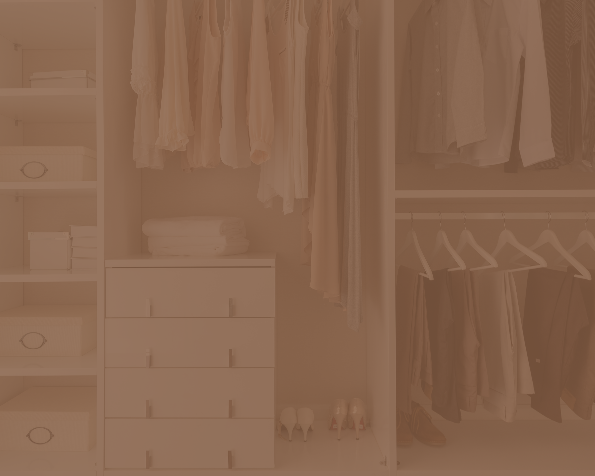 A walk-in closet with shelves of folded clothes, hanging shirts and pants, white shoes, and storage boxes.
