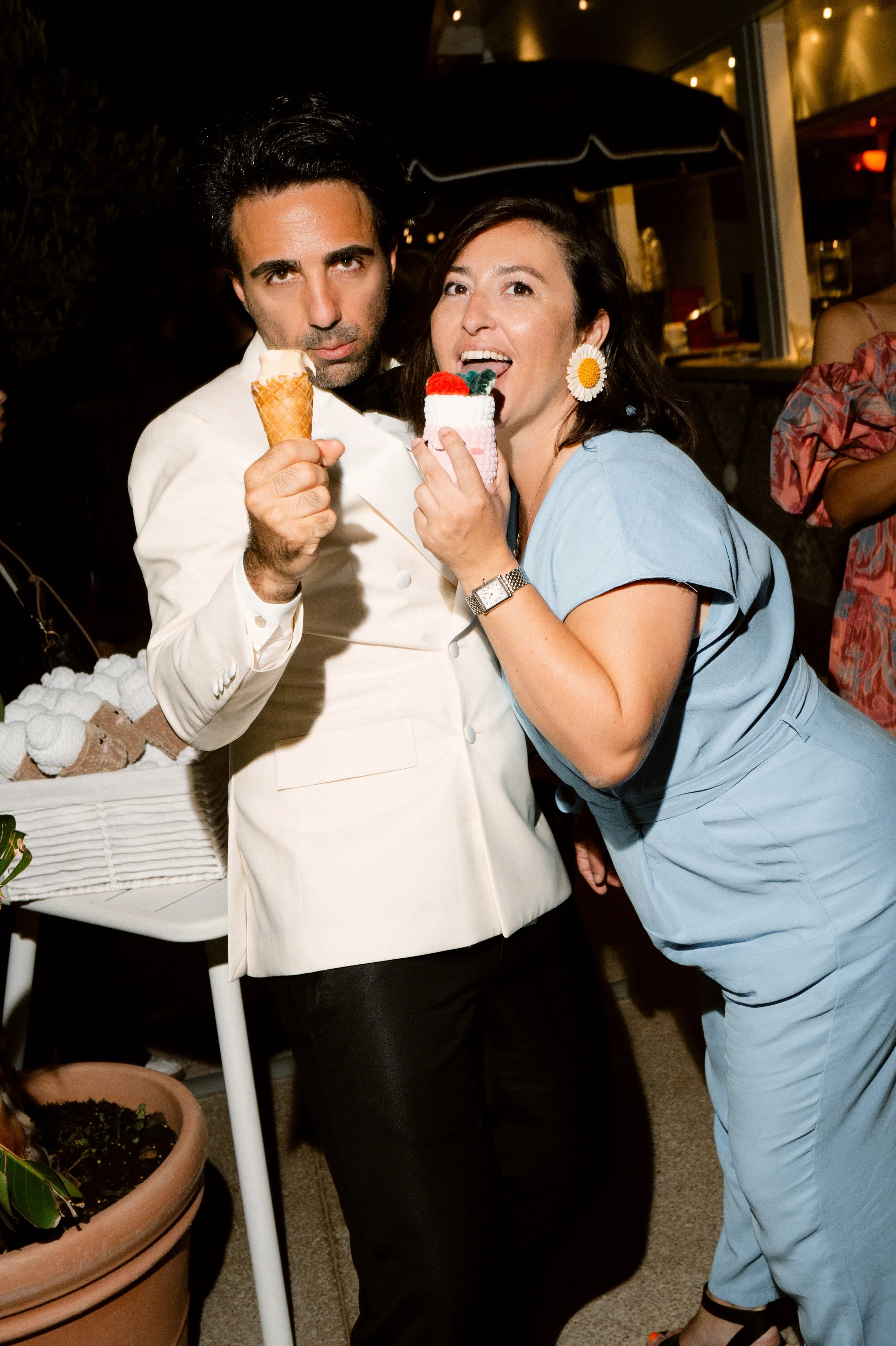 A man and woman enjoying ice cream and cake at a wedding.