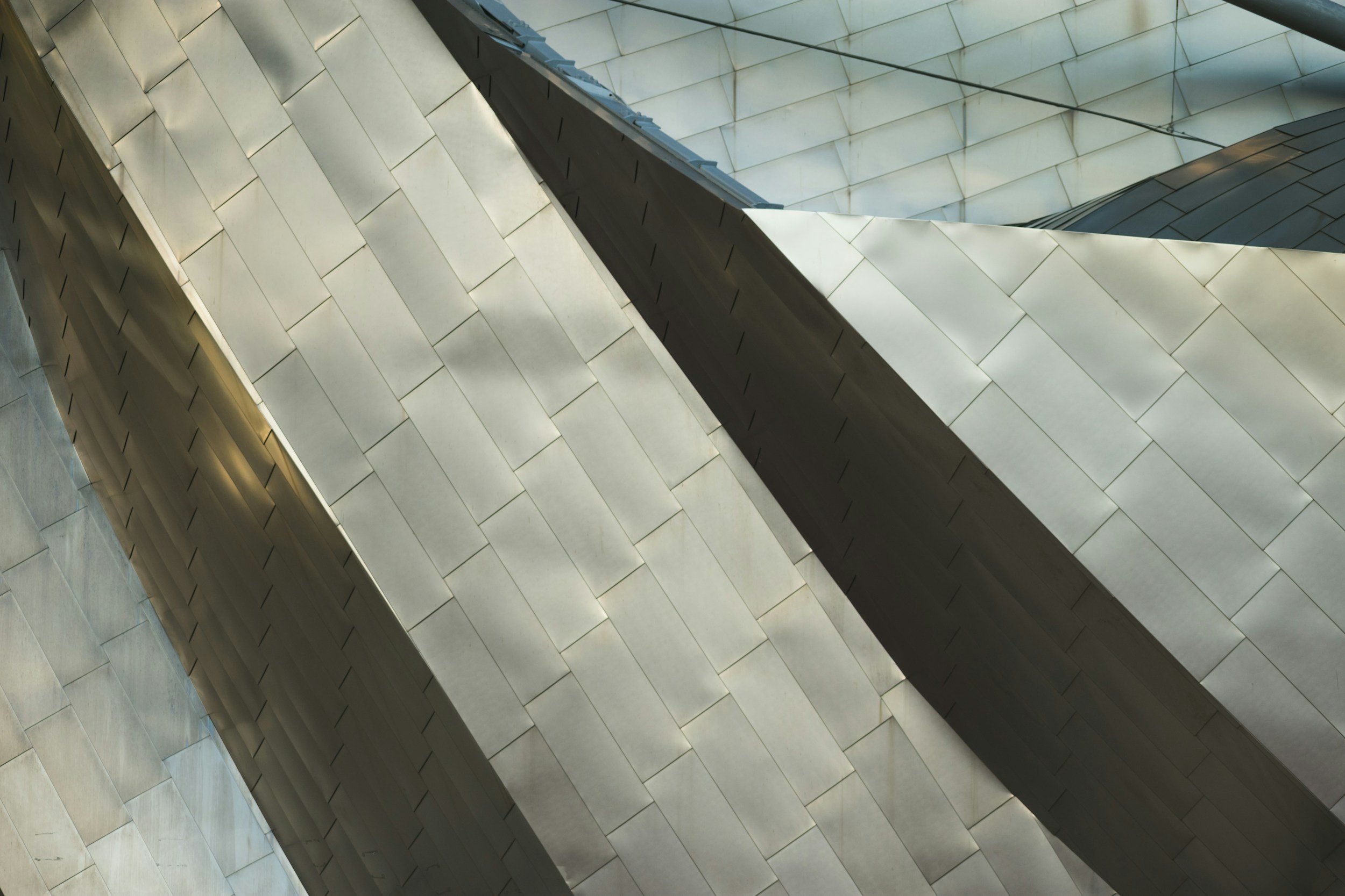 Close-up of a modern building's metallic facade with overlapping panels and angular design.