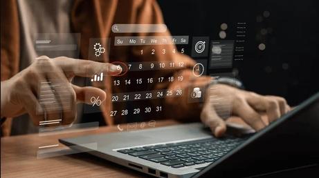 Person using a laptop with virtual interface showing calendar, graphs, and data analytics overlaid.