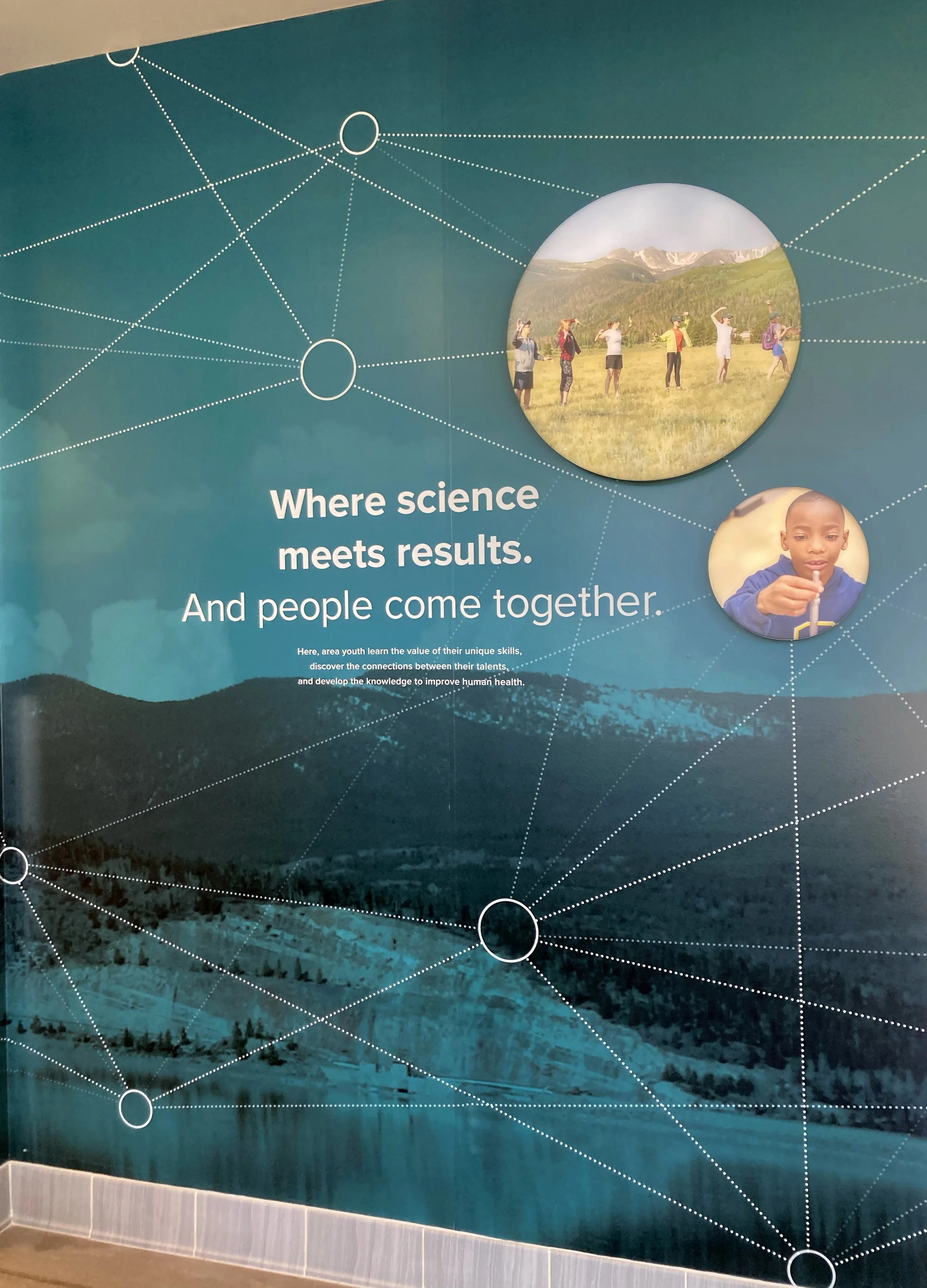 Wall graphic with people doing science.