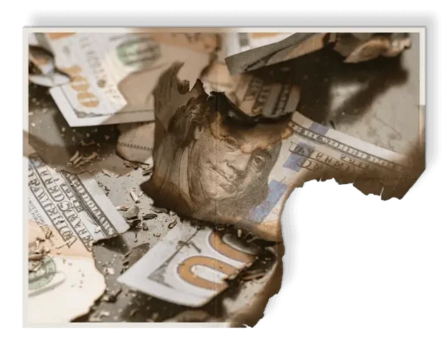 Burned and torn U.S. hundred-dollar bills, with some pieces partially singed and others shattered representing asset loss without impact windows and doors in Pinellas County and Tampa Bay area businesses and homes