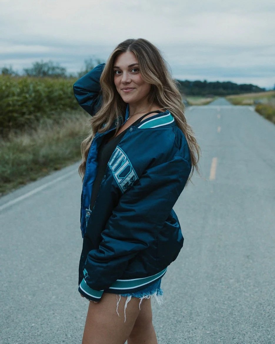 Destinee Horat wearing her long dimensional brunette hair color outdoors on a country road