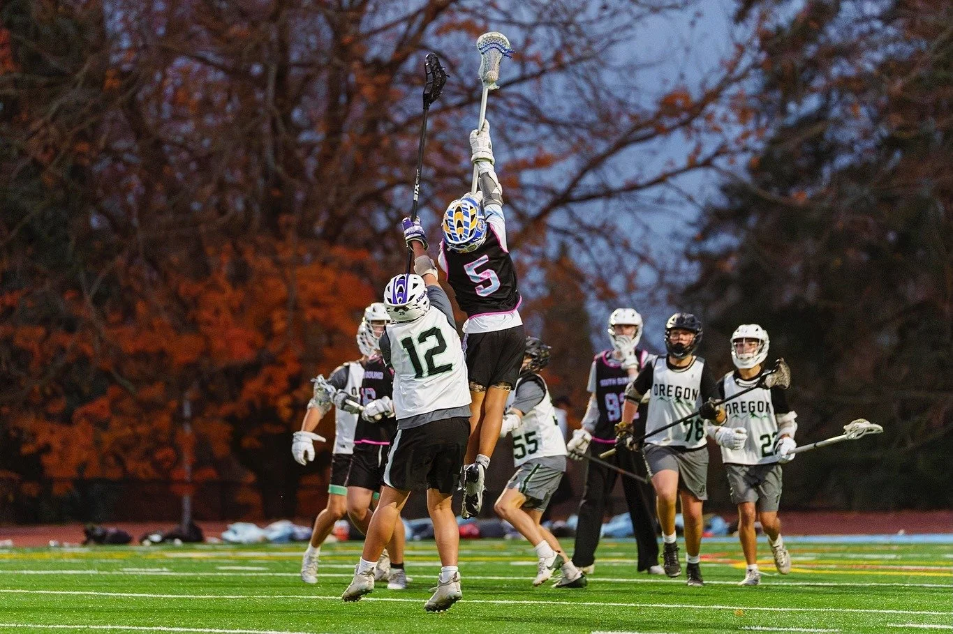 A player leaps to catch a high pass in front of autumn trees at the 2025 Oregon Fall Classic