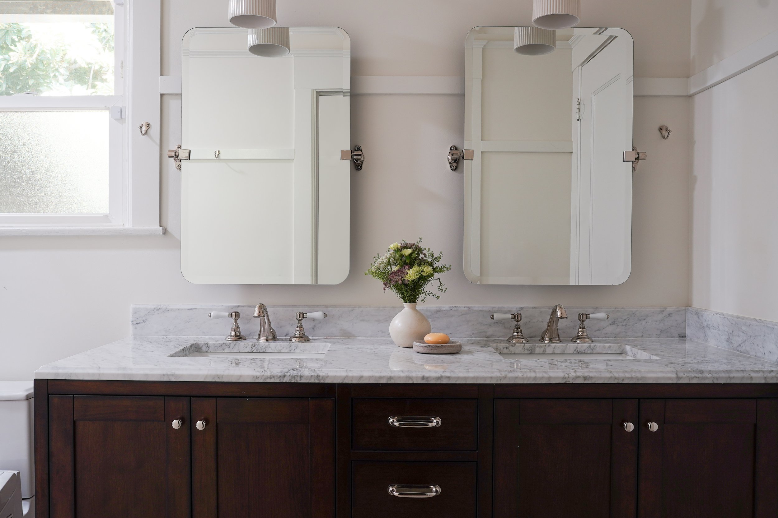 Elmwood Craftsman primary bathroom with marble double vanity, dark wood cabinetry, nickel fixtures, and dual mirrors — residential interior design by Kit Studio, Berkeley