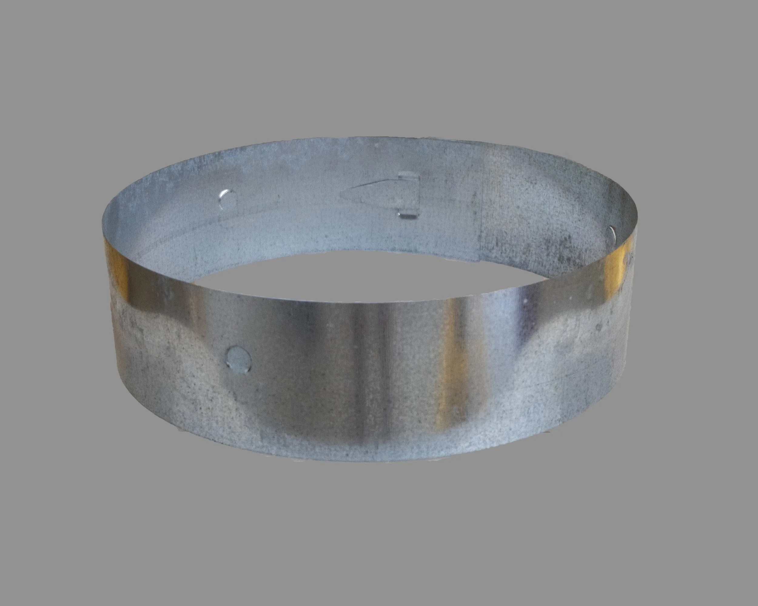 Metal ring with holes on a gray background.