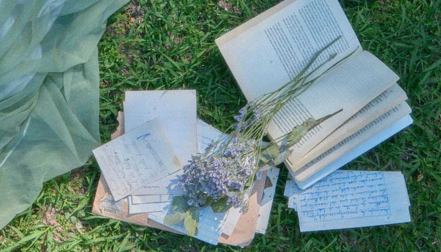 books and letter sitting in grass