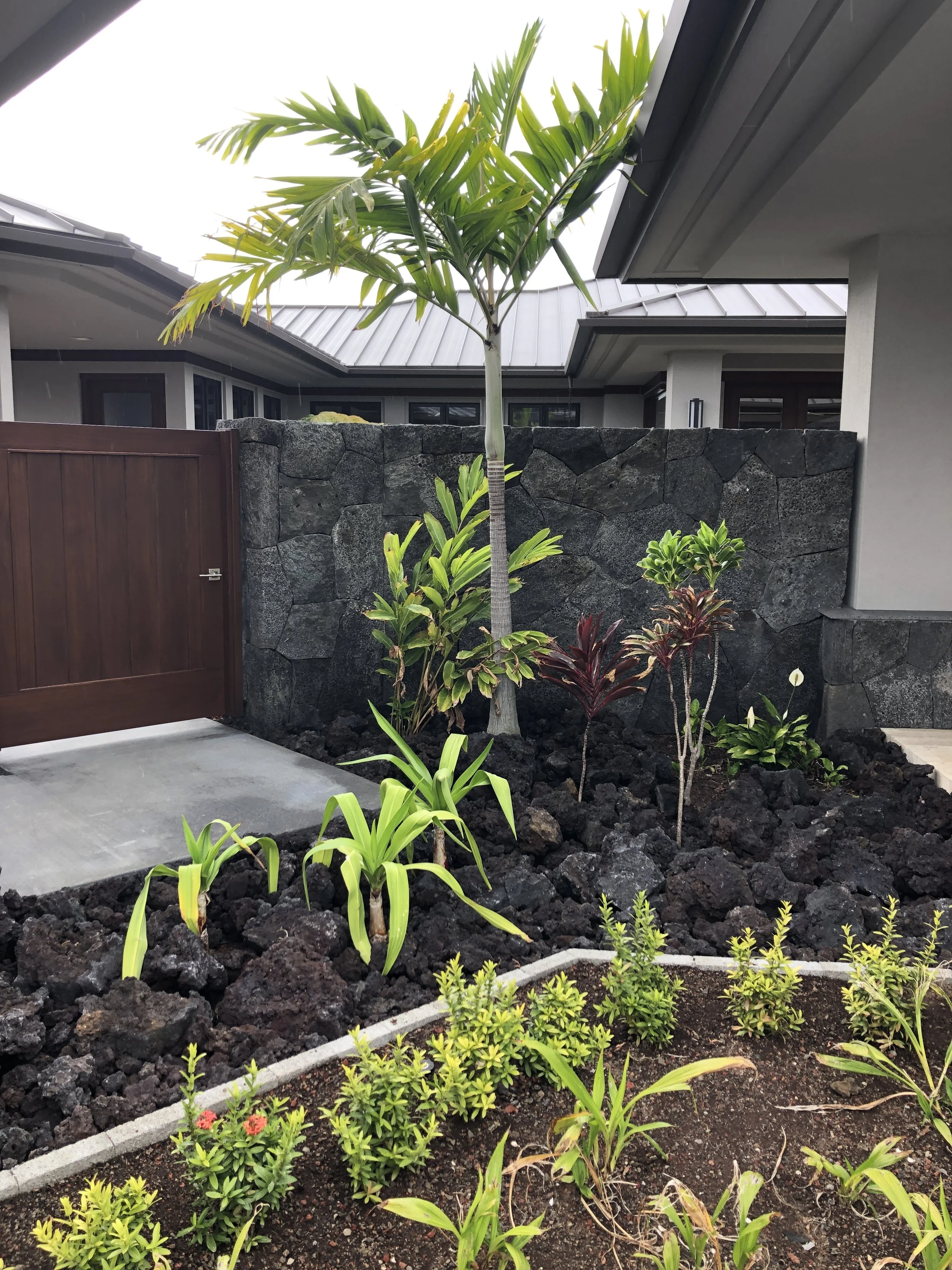 Traditional Hawaiian dry-stack stone walls by Kona Hema Stonemasonry LLC on the Kona Coast of Hawaiʻi Island, using local basalt pōhaku and ʻuhau humu pōhaku craftsmanship to build structural retaining walls, Kona rock walls entrance signs stonewall 