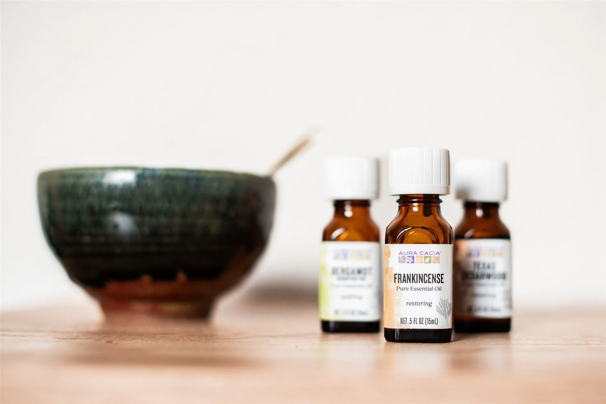 Three bottles of essential oil and a ceramic bowl used in Chinese Medicine at Apo Acupuncture in Orinda, CA.