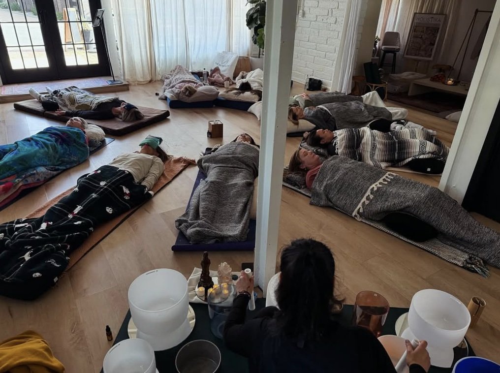 People lying on mats and blankets on the floor during a sound healing  and acupuncture sessions in Lafayette, CA.
