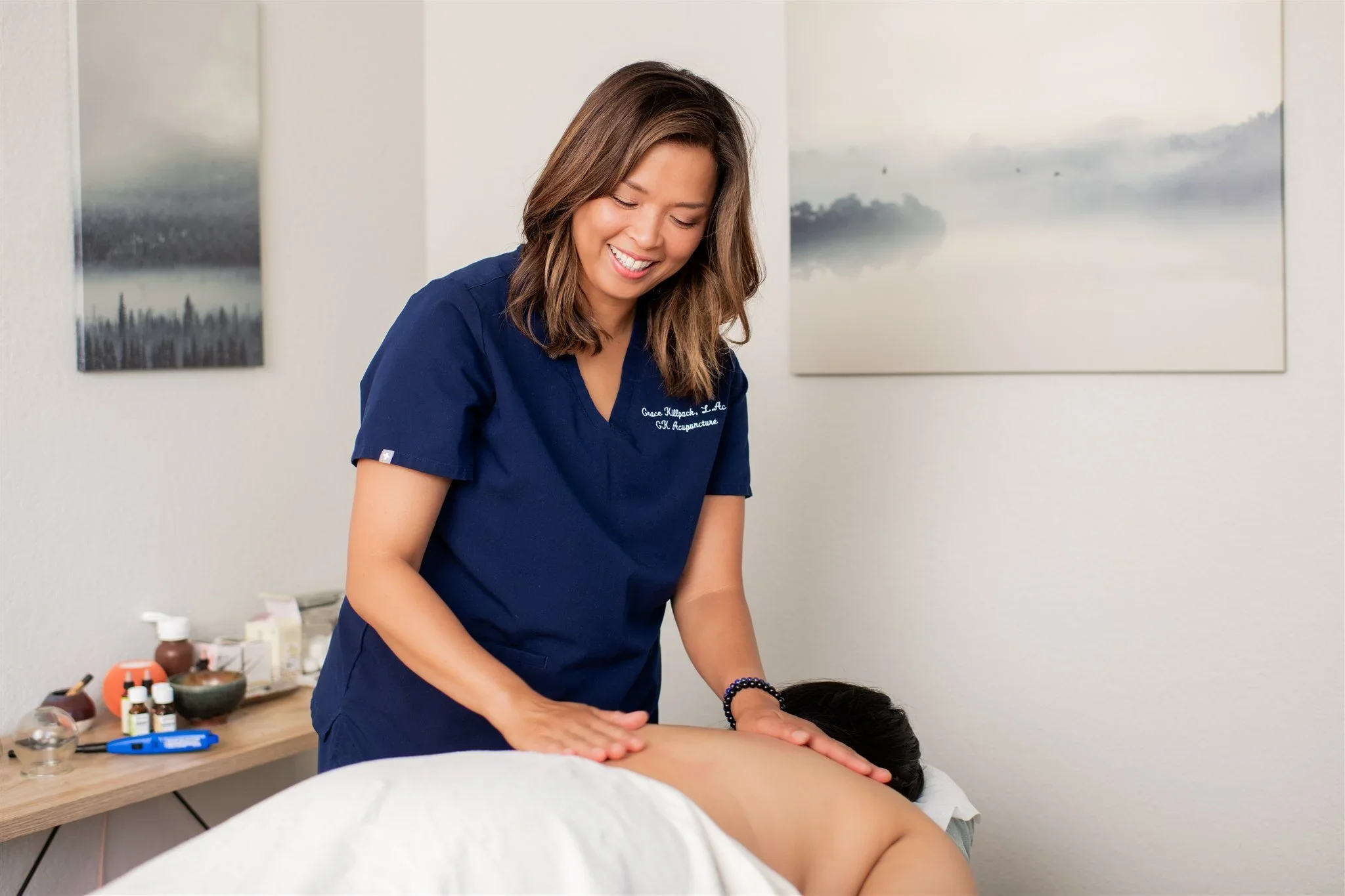 Acupuncturist Grace Killpack providing pain relief on a woman's back at her clinic Apo Acupuncture near Lafayette, CA.