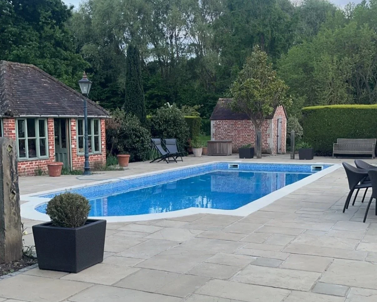 Outdoor hard landscaping surrounding an outdoor swimming pool by CloudNine Construction, Surrey, UK
