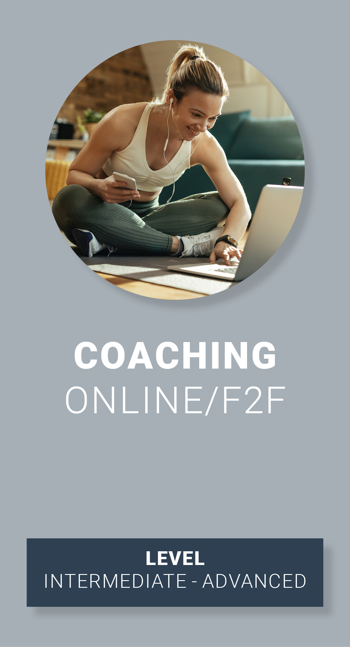 A woman in workout clothes sitting on the floor during an online coaching session, smiling, with a laptop and phone, in a cozy home setting.