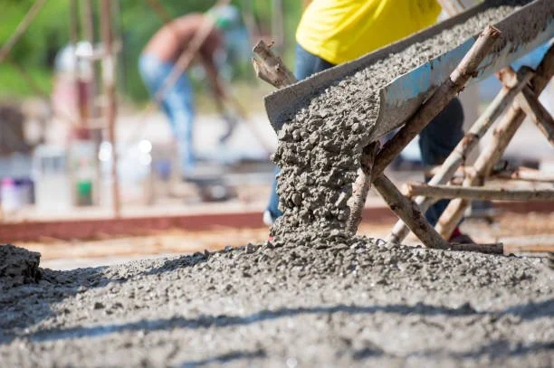 Close-up of concrete being poured from a wheelbarrow during a construction project.