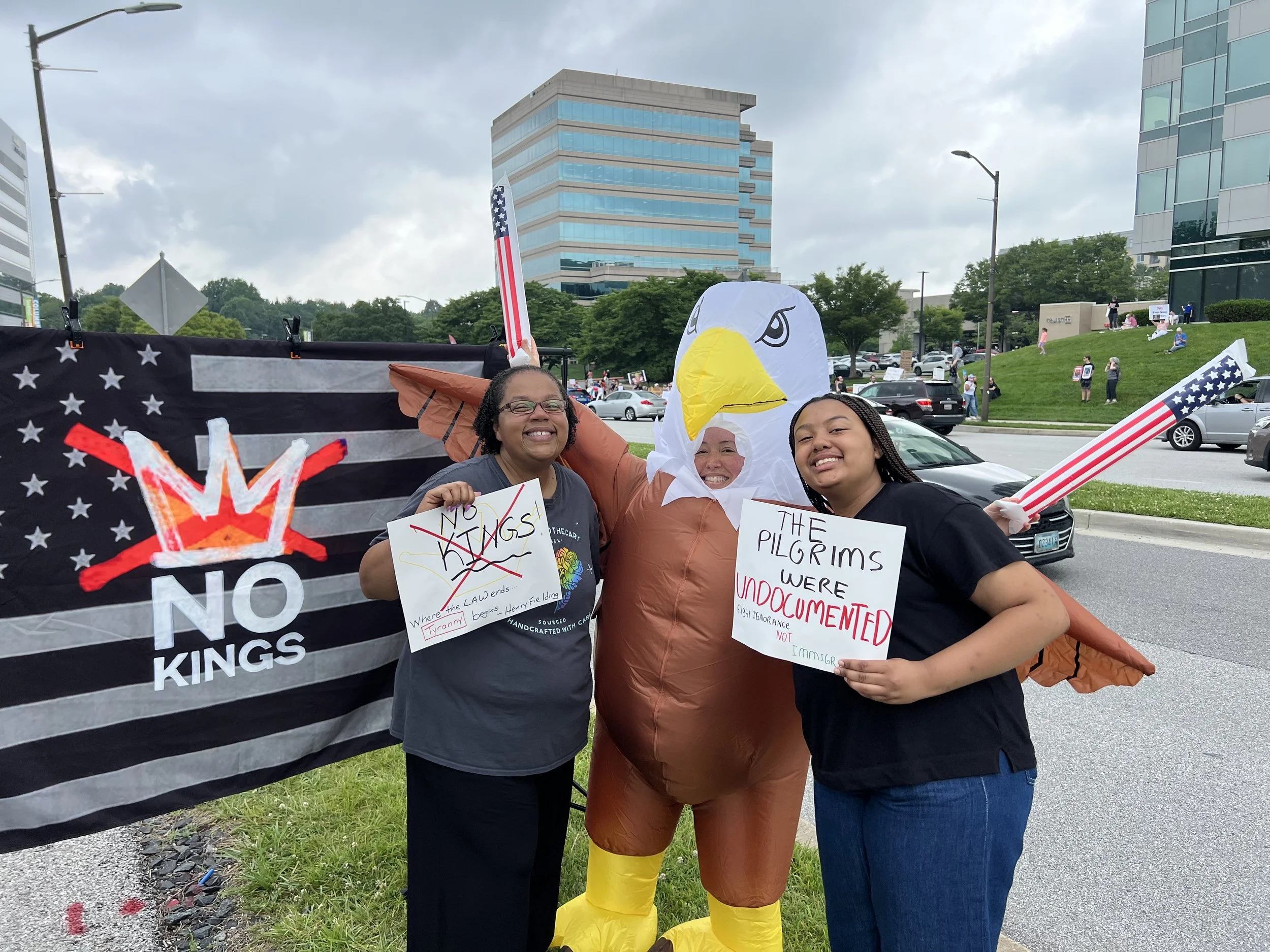 Jessica Nichols and her daughter posing with someone in an blow-up eagle costume at a No Kings rally