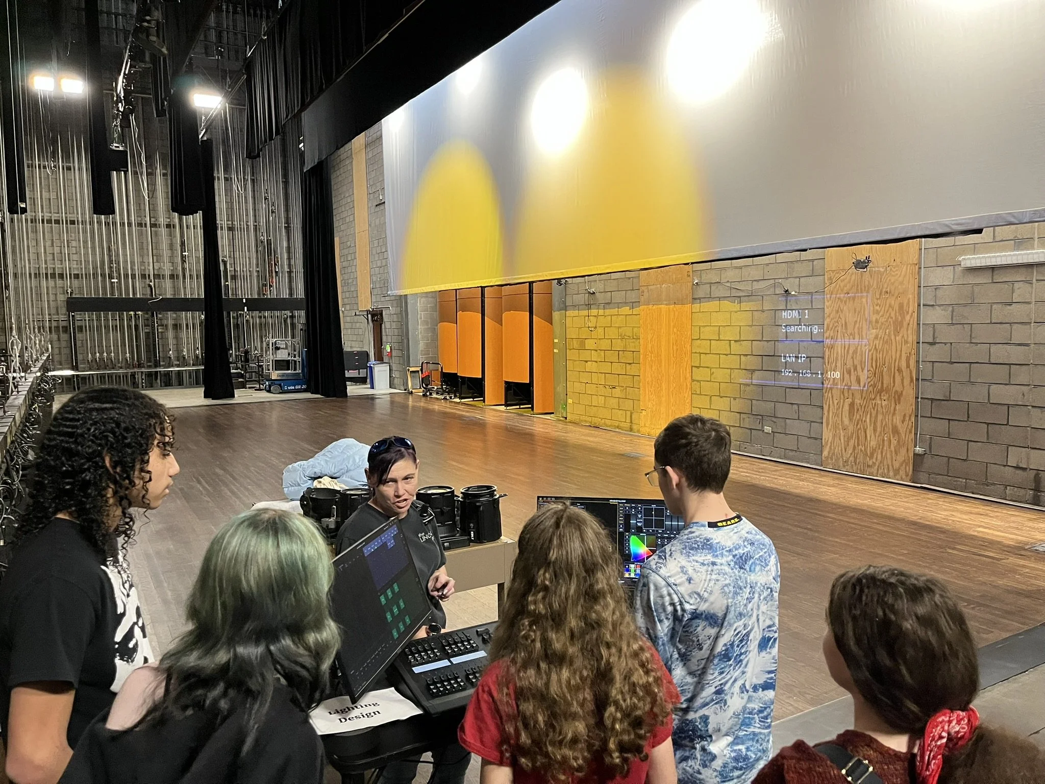 Students learn lighting design and color mixing backstage with theater staff during Tech Career Day at the Lincoln Center