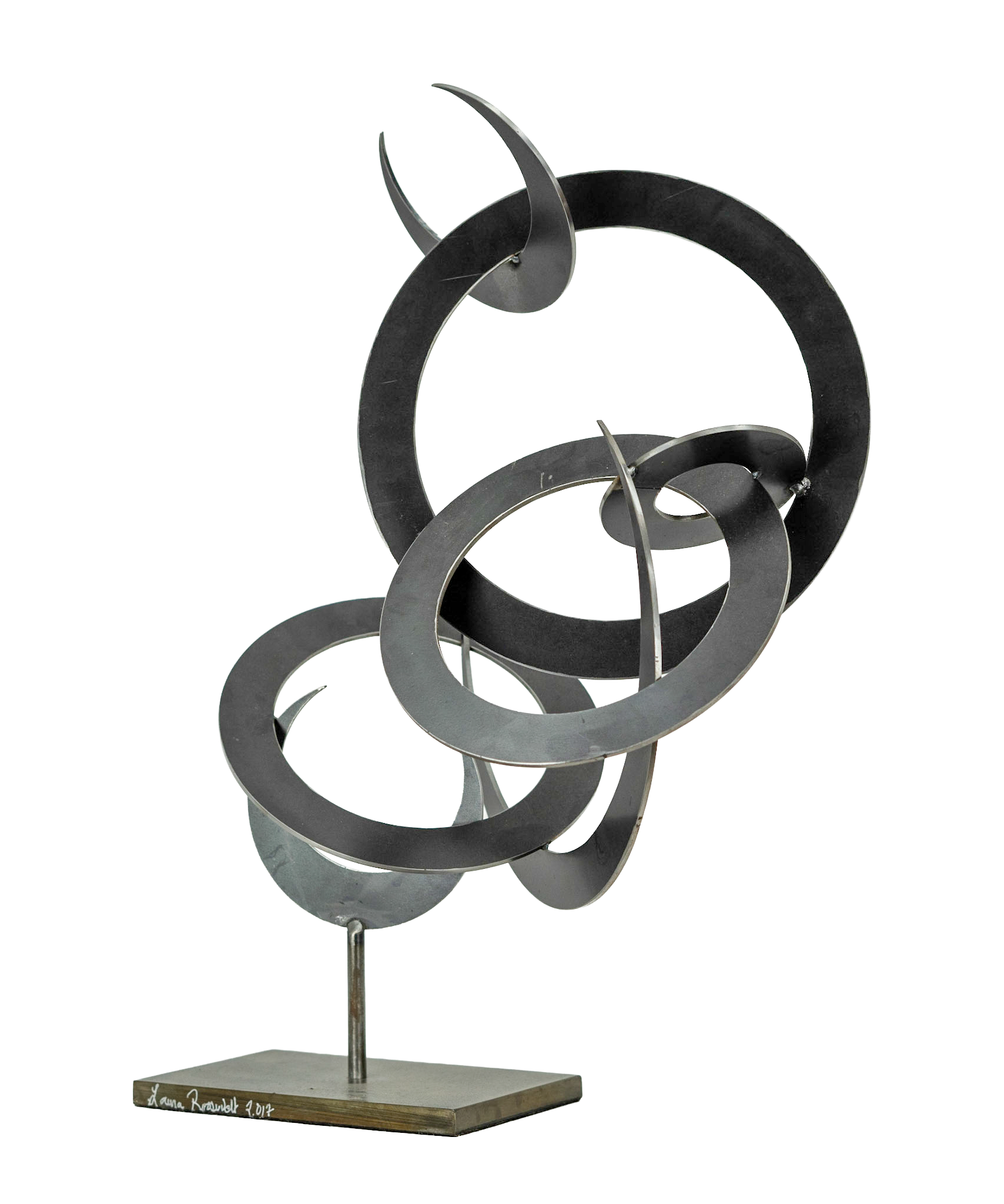 Abstract metal sculpture with intertwined circular and teardrop shapes on a wooden base.