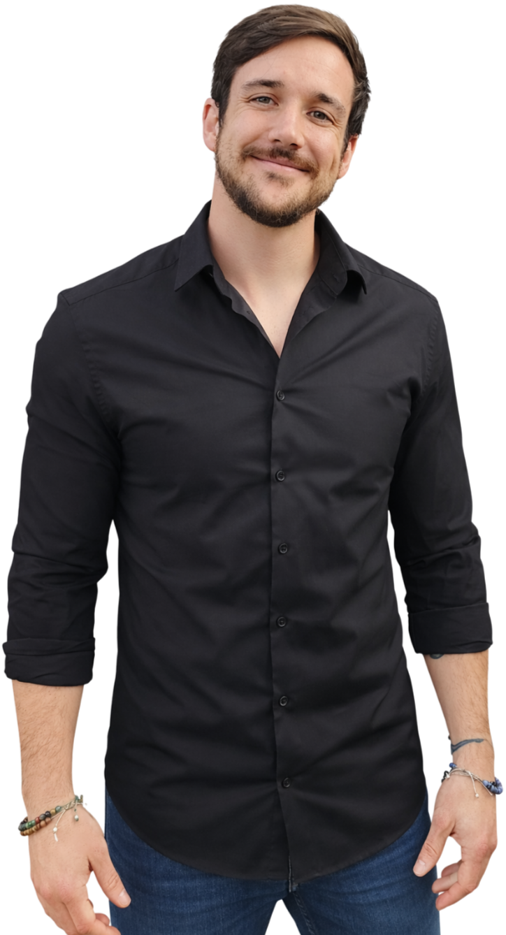 A young man with short brown hair and a beard, smiling, wearing a black button-up shirt with the sleeves rolled up and dark blue jeans.