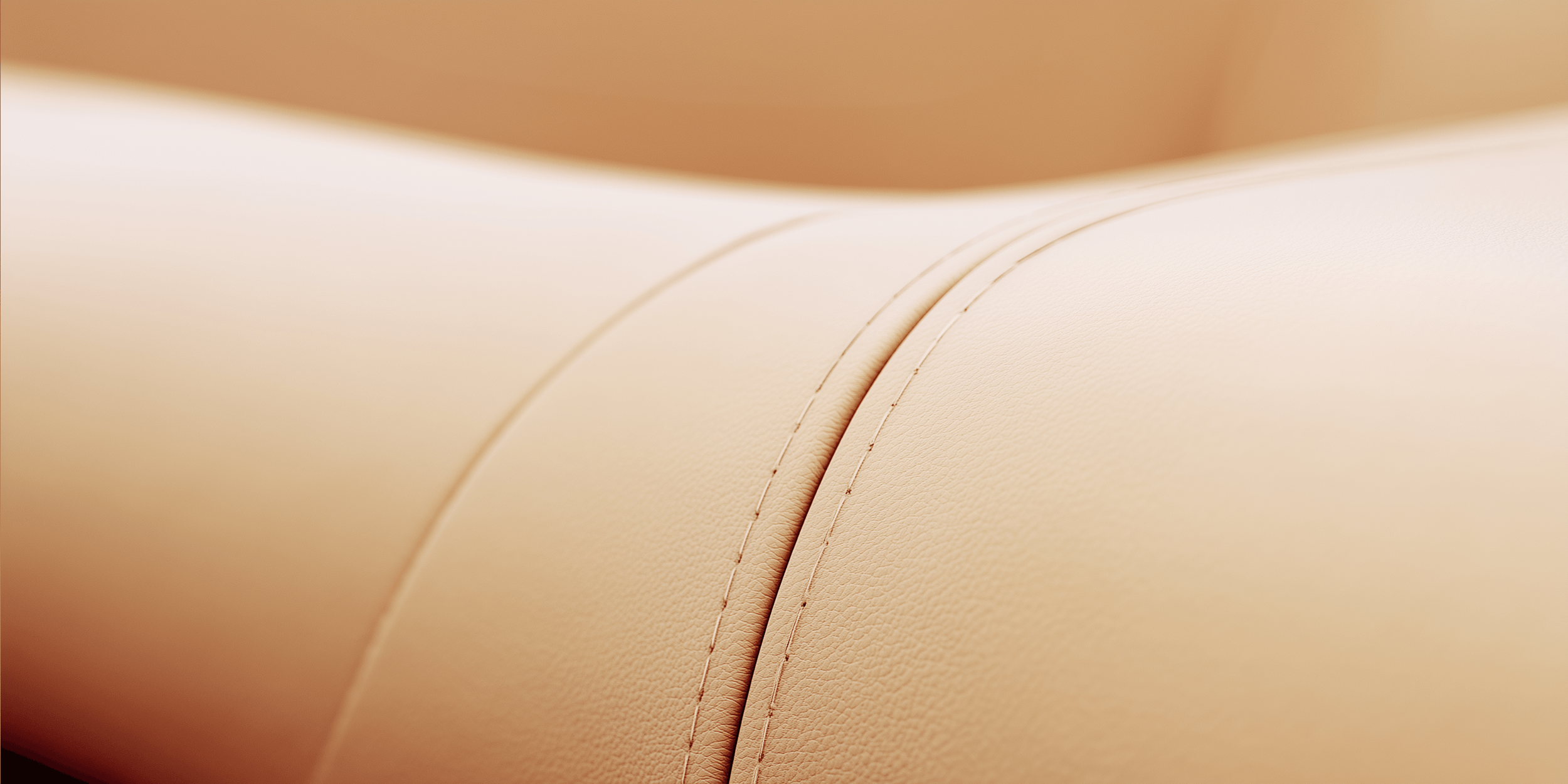 Close up of beige leather upholstery with clean stitching, illustrating the results of leather cleaning and conditioning offered by By Goldenburg.