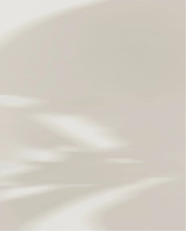 Blurred, abstract light-colored background with soft streaks and smooth gradients.