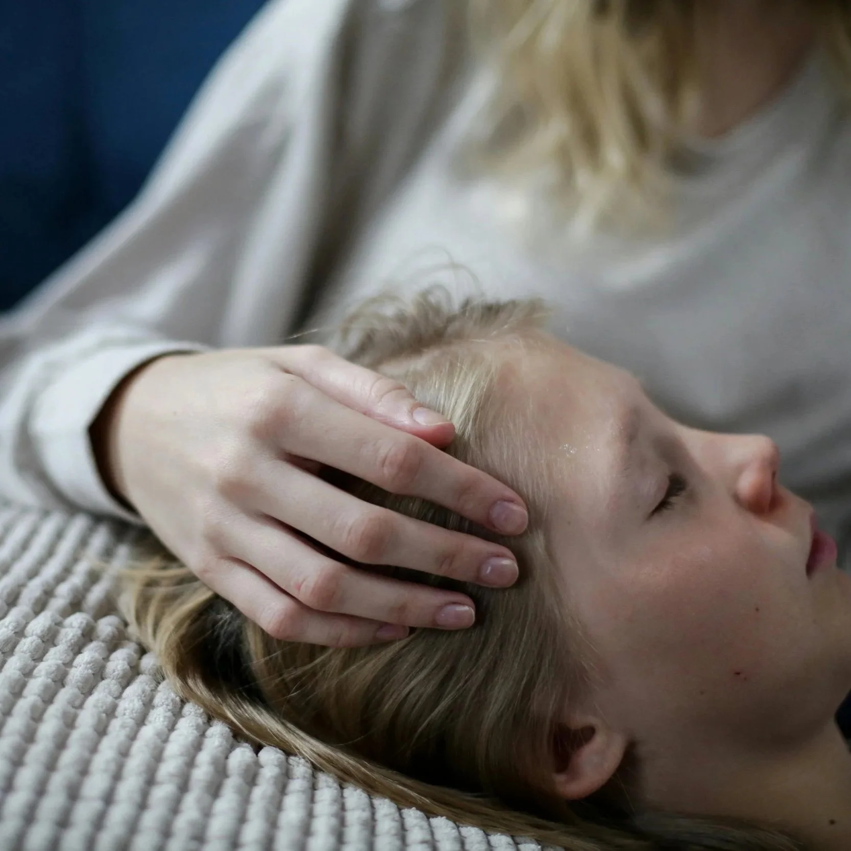 A person receiving a head massage while lying down.
