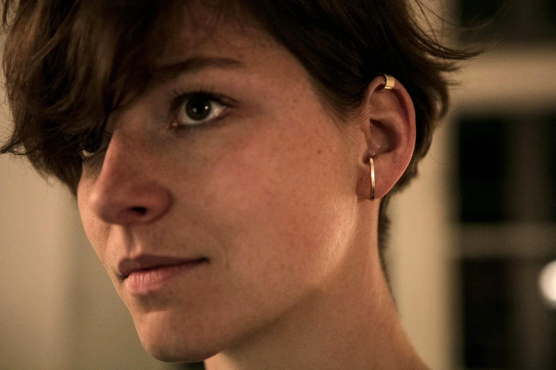 Zlatá náušnice a earcuff na uchu