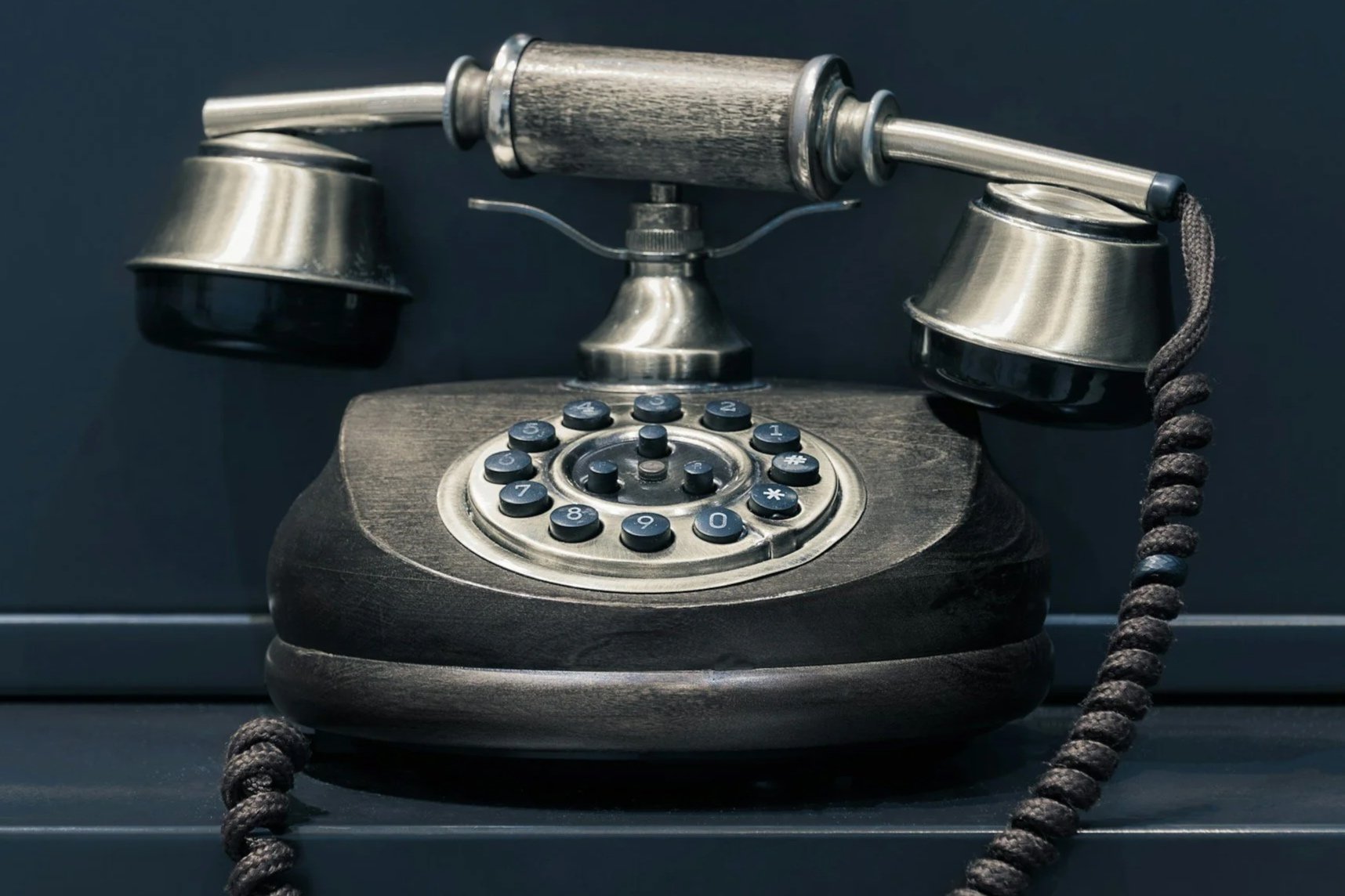 Vintage black and silver rotary telephone with rotary dial and cord, symbolizing a safe space to talk