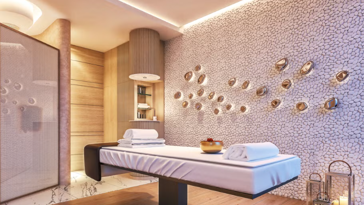 Spa or massage room with a massage table, hose, and towels, decorated with metallic wall sculptures.