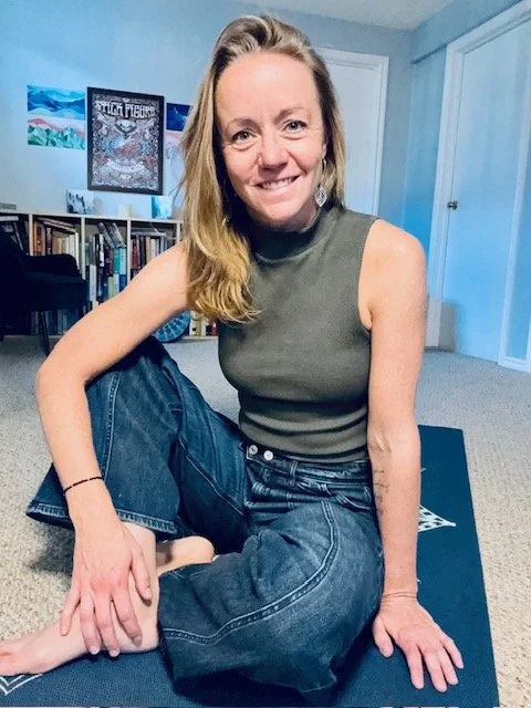 Headshot of Erica Blain sitting on a yoga mat