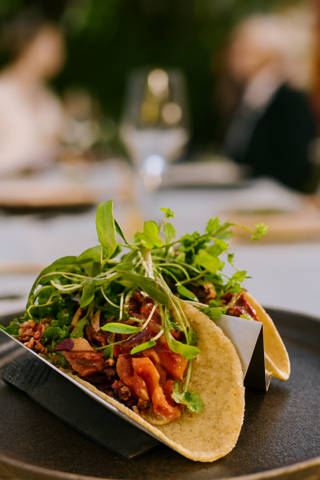 Pulled pork tacos filled with diced tomatoes, fresh greens, and topped with vibrant microgreens. Served outdoors on a metal tray, this dish captures flavour, freshness, and flair a JustInc. private chef creation enjoyed across South England.