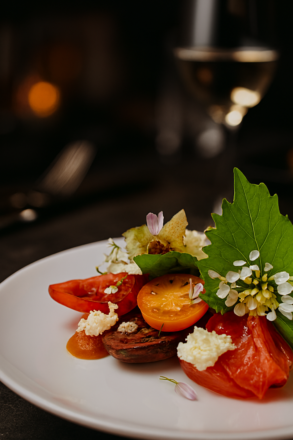 Heirloom tomato salad, smoked tomatoes, aged balsamic, homemade ricotta, foraged hedgerow herbs, and tempura chive flower. A vibrant showcase of flavour and texture, crafted by JustInc. for private chef menus and bespoke events across South England.