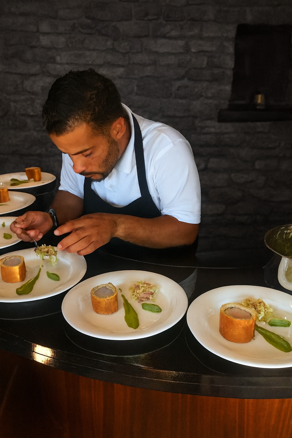 Founder Justin Knight presents pork en croute with broccoli textures at a fine dining dinner. A JustInc. private chef creation showcasing precision, artistry, and hospitality across South England.
