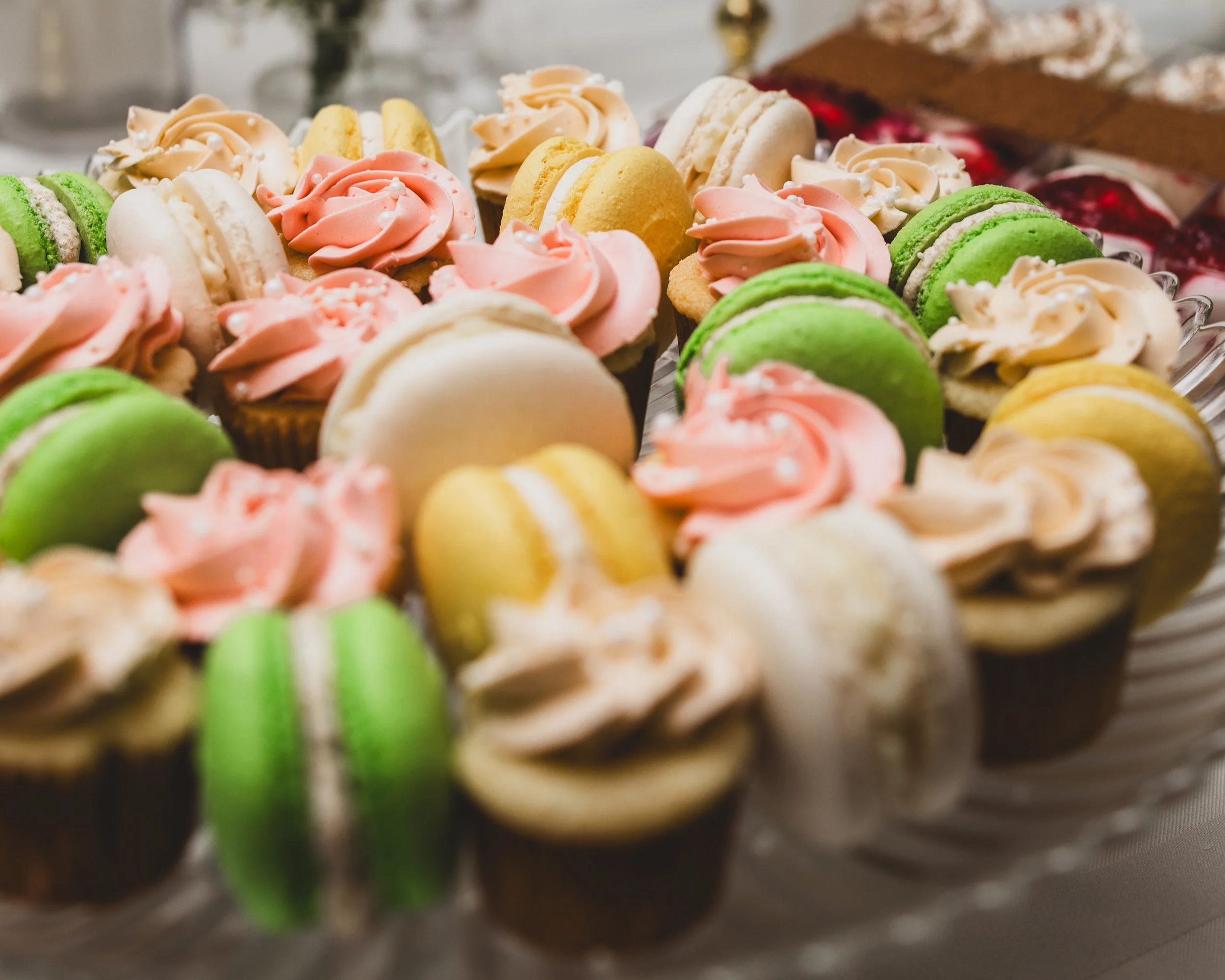 Assorted colorful cupcakes and macarons on a platter