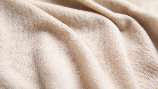 Close-up of beige fabric with soft folds.