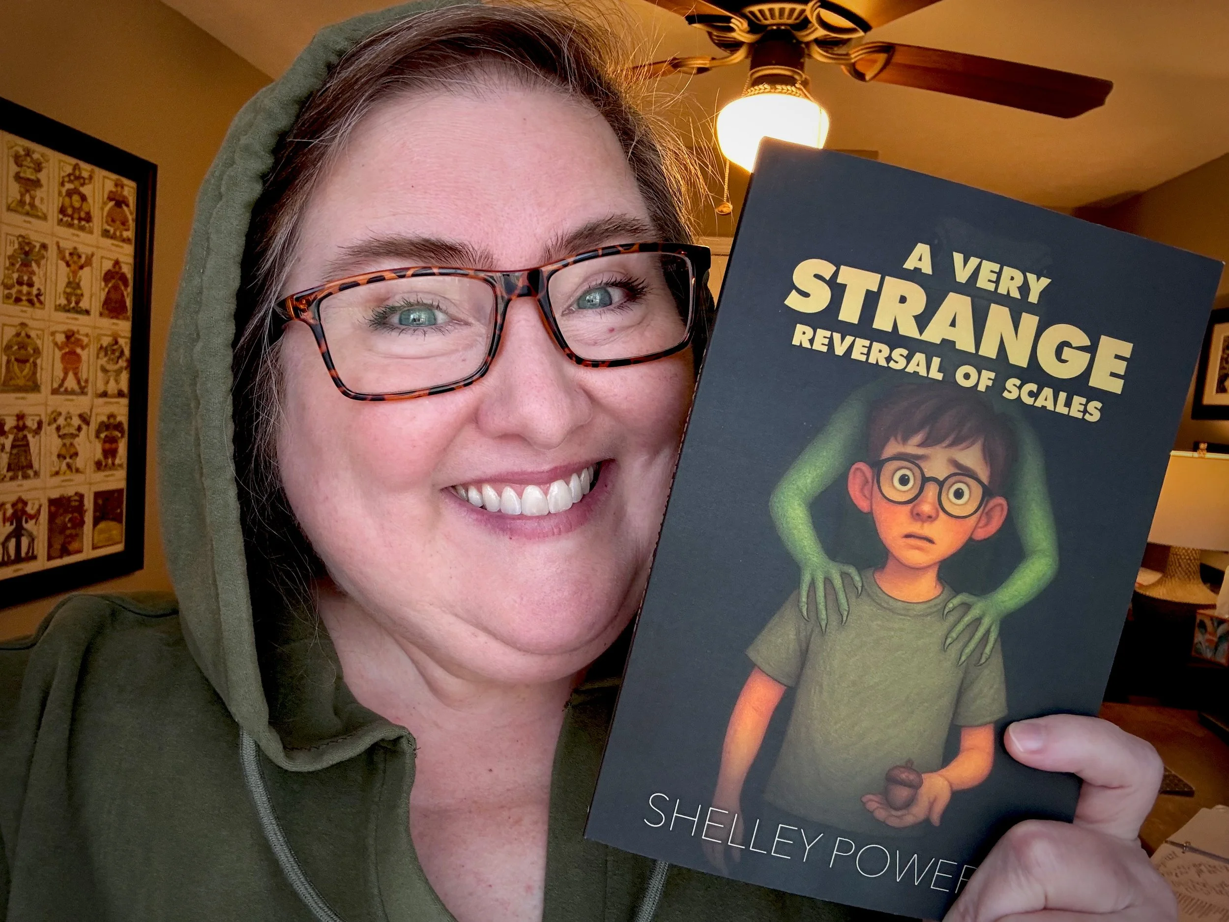 Author Shelley Powers holds the debut book for Creekline House, A Very Strange Reversal of Scales