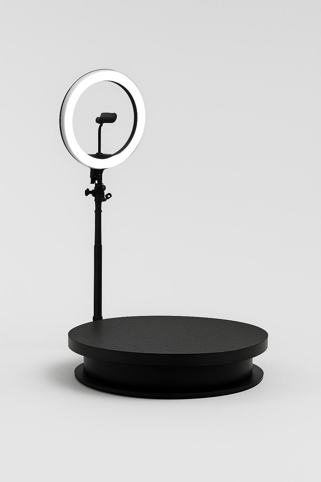 A black ring light mounted on a stand, positioned above a circular black platform.