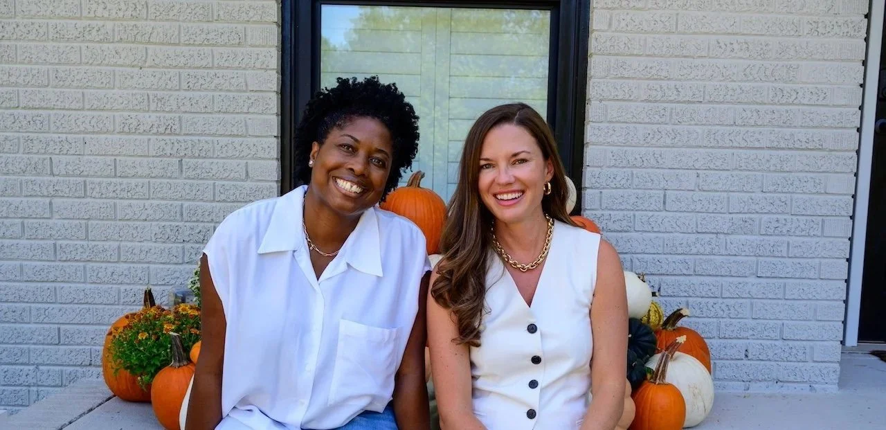 Janica Jordan and Natalie Warren. Two women sitting outside in front of a house with pumpkins and flowers, smiling for the camera.