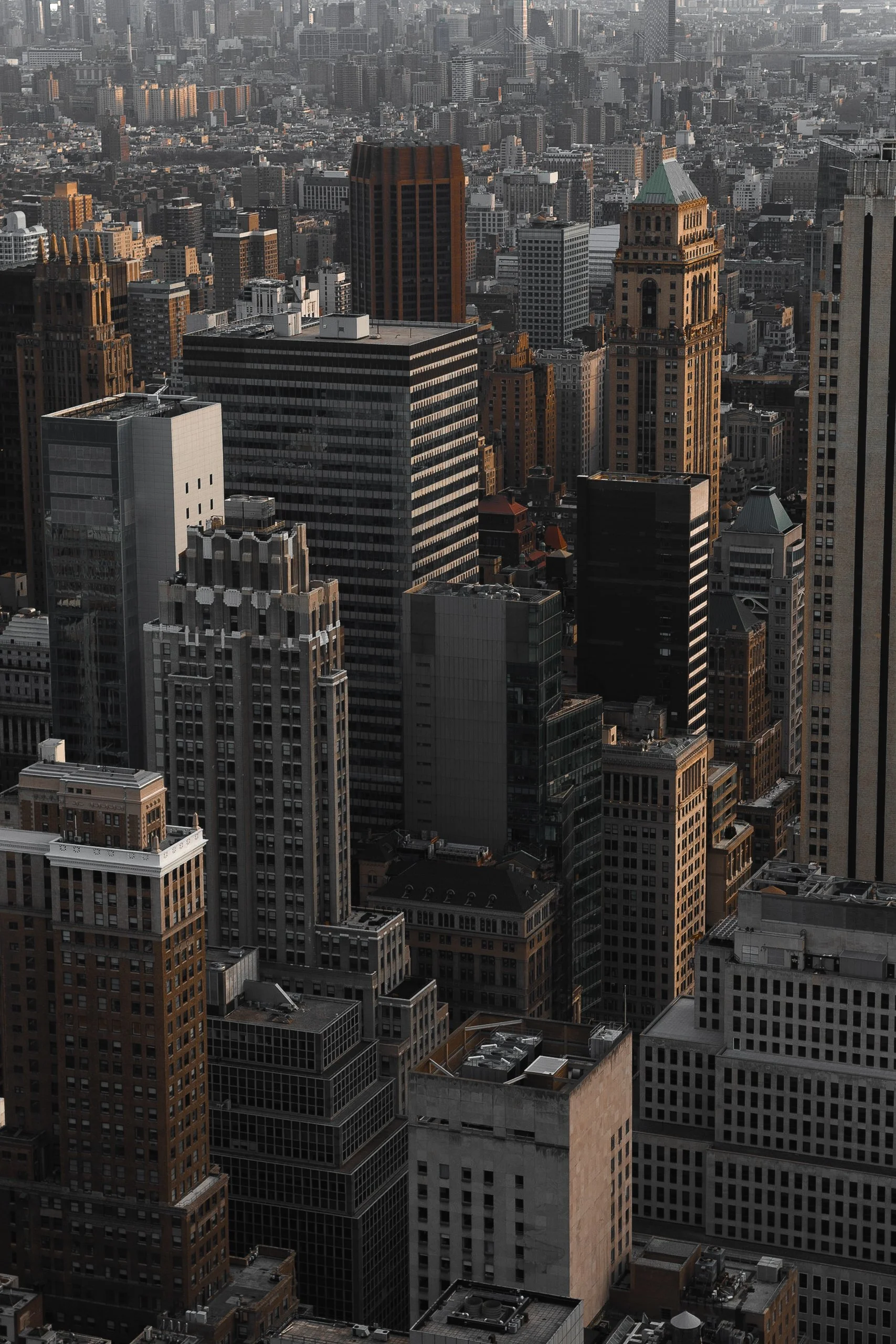 Aerial view of a dense cityscape with numerous high-rise office buildings and skyscrapers, showing a variety of architectural styles and materials in a metropolitan area.