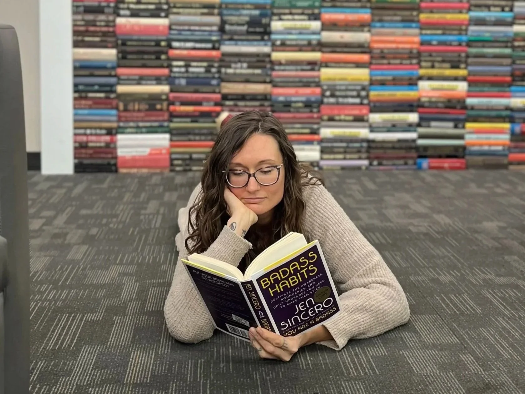 Ashana Kaiulani lying on a bookstore floor reading a book