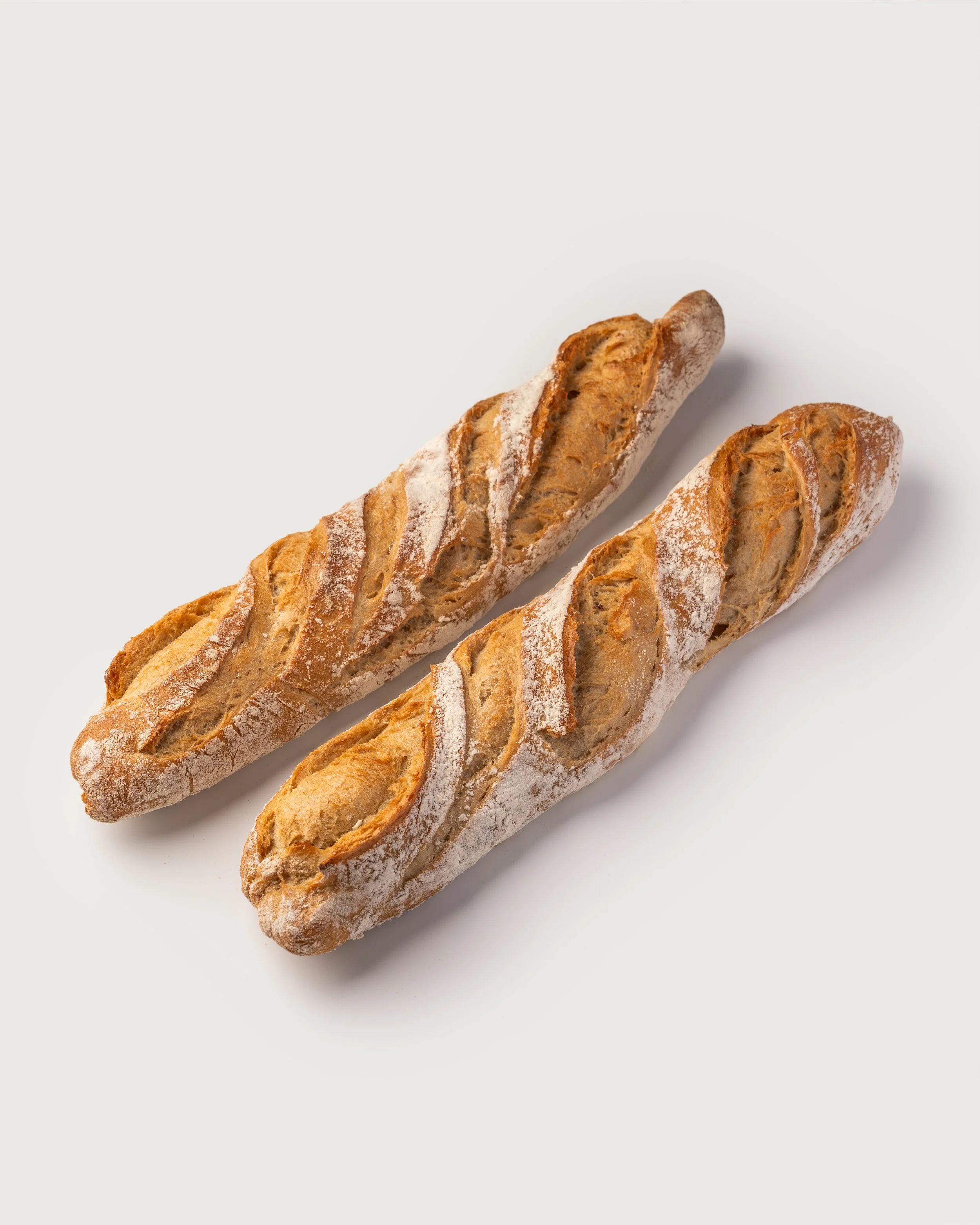 Two Baguettes Tradition — crisp, flour-dusted French baguettes, Social Goods Modern Bakery.