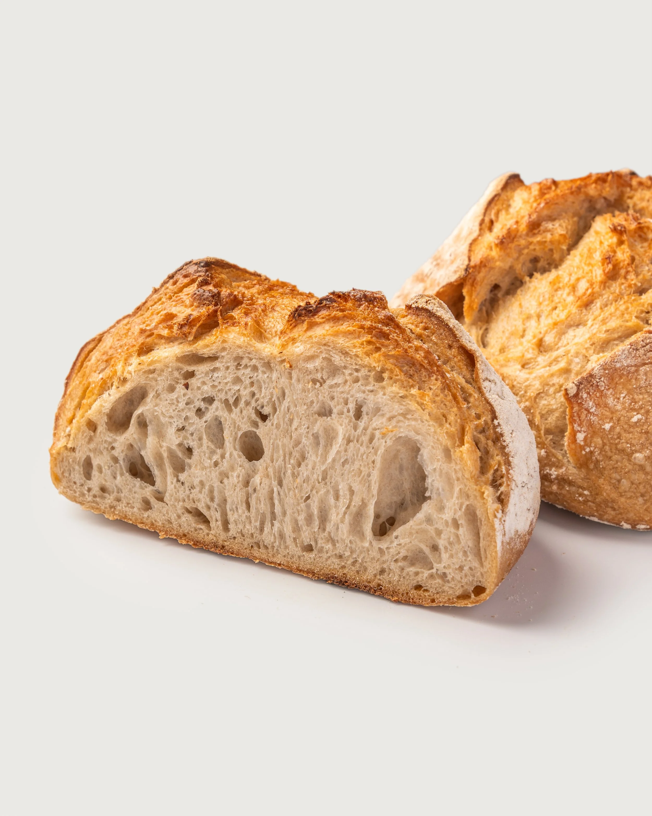 Classic Sourdough sliced to show open crumb and crisp crust, Social Goods Modern Bakery.