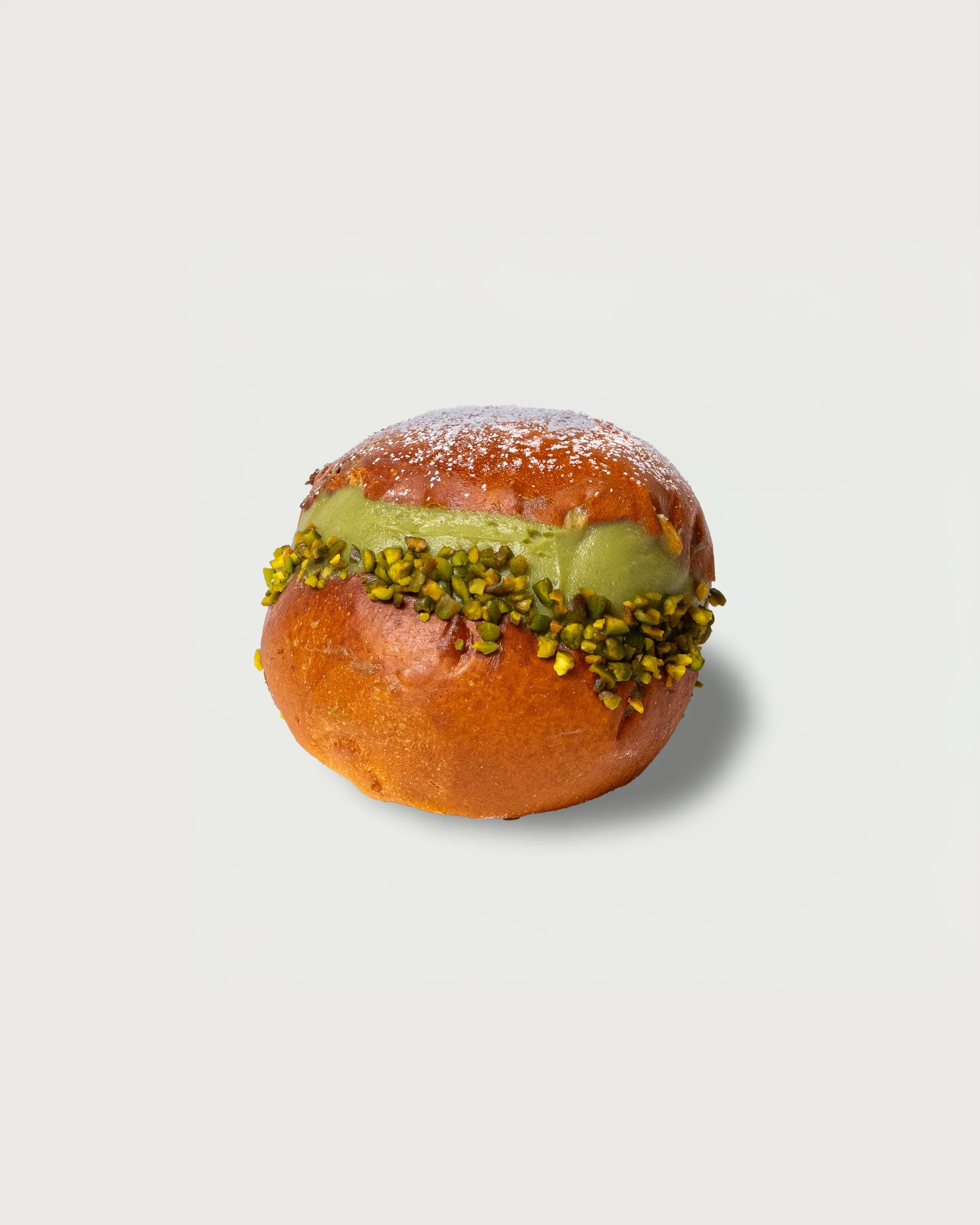 Pistachio Maritozzi — brioche bun split and filled with whipped cream, topped with chopped pistachios.